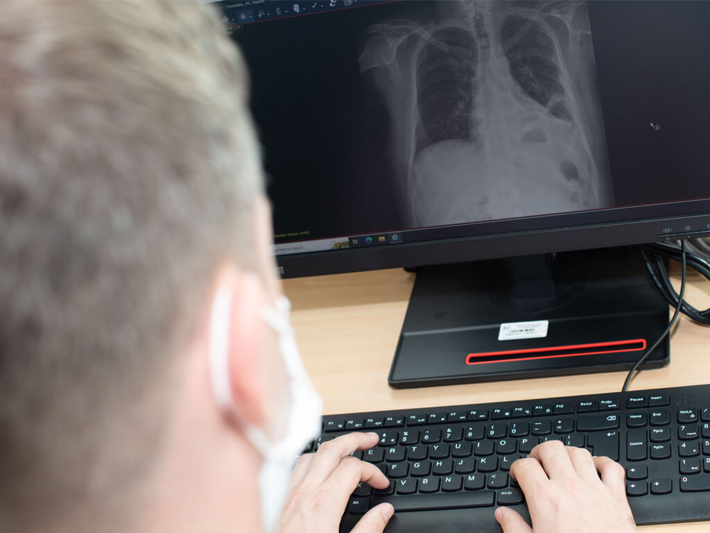 Male Trainee working a computer station with an image of the respiratory system visible on computer screen